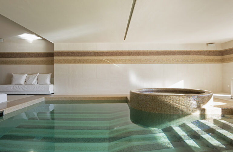 Indoor pool of private villa with lake view and bar area. Nobody inside