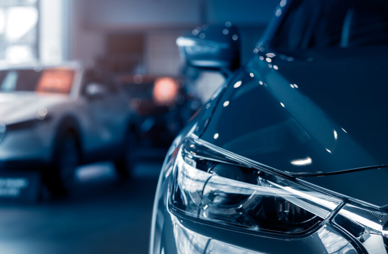 Selective focus grey car parked in luxury showroom. Car dealership office. New car parked in modern showroom. Car for sale and rent business concept. Automobile leasing and insurance background.