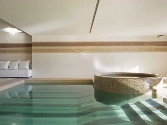 Indoor pool of private villa with lake view and bar area. Nobody inside